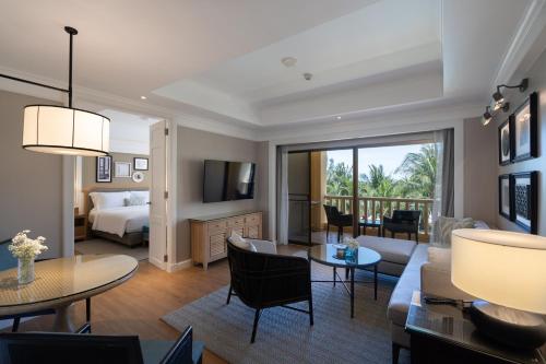 a living room with a bed and a living room with a couch at Dusit Thani Hua Hin in Cha Am