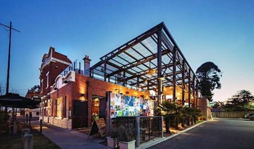 a building with awning on the side of a street at Treehouse Hideouts Balcony Apartment - Port of Echuca Townhouse in Echuca
