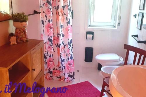 a bathroom with a toilet and a shower curtain at Casetta il Melograno Accogliente Bilocale al Mare in Villaggio Mosè