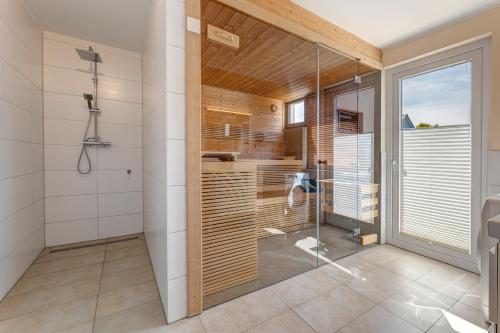 a bathroom with a shower and a glass shower stall at Ferienhaus 6 Schlafzimmer mit Sauna UnserUsedom Ostseebad Koserow Insel Usedom in Ostseebad Koserow