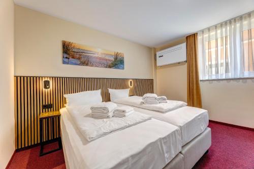 a bedroom with two beds with white sheets at Fewo Karlstraße 14 - Ostseebad Koserow in Ostseebad Koserow