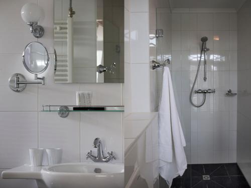 a bathroom with a sink and a shower with a mirror at B & B Hotel The Baron Crown in Den Helder