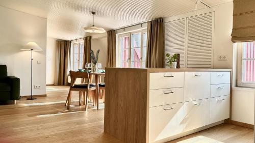 a kitchen with white cabinets and a dining room at City Center Appartment in Vilnius