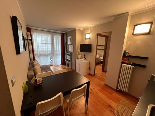 salon ze stołem i krzesłami oraz salon w obiekcie Casa Monique - Borgo Le Stalle Lunghe w mieście Prato Nevoso