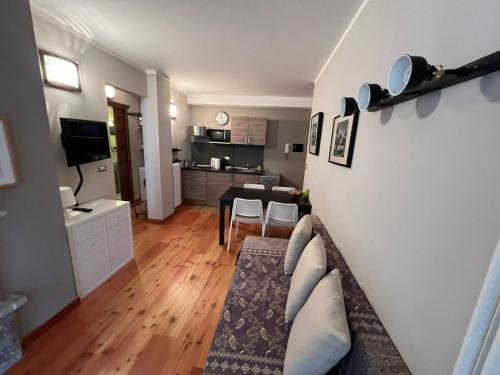 salon z kanapą i kuchnią w obiekcie Casa Monique - Borgo Le Stalle Lunghe w mieście Prato Nevoso