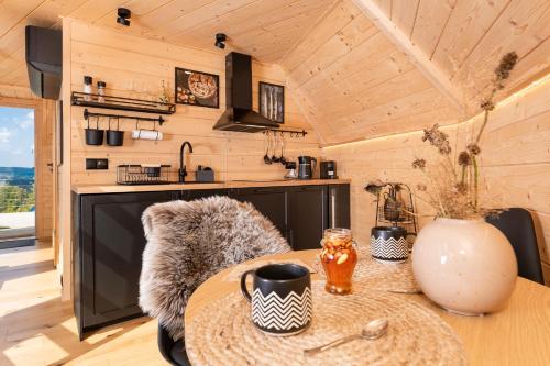 a kitchen and dining room in a tiny house at Osada Poli Zawoja - Panoramiczny Domek z Prywatną Balią i Hydromasażem in Skawica
