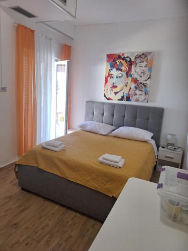 a bedroom with a large bed with two towels on it at Guest house Renata 2 in Zadar