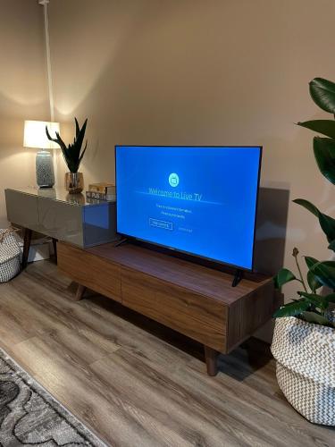 a flat screen tv sitting on a wooden table in a living room at Development House in West Bromwich