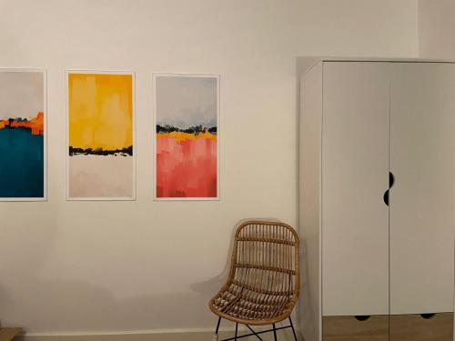 a chair in a room with paintings on a wall at Development House in West Bromwich