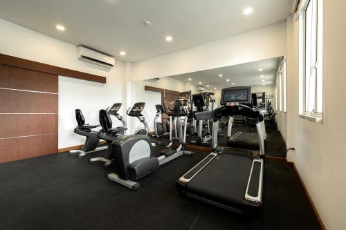 a gym with several treadmills and a television at Niraxay Apartment in Vientiane