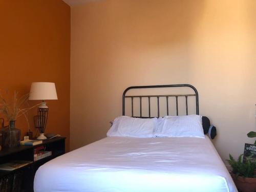 Una cama con sábanas blancas y almohadas en una habitación. en Le petit matelot, en Paimpol