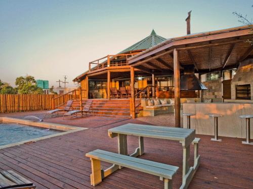 a building with a picnic table on a deck at Silverstreams Lodge, Villas & Cottages, Oribi Gorge in Glendale