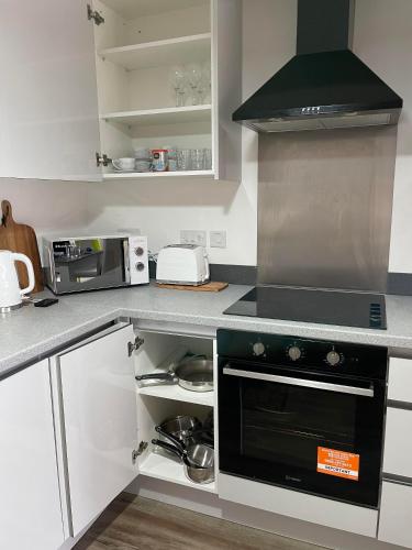 a kitchen with a stove and a microwave at Development House in West Bromwich