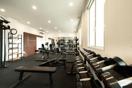 a gym with rows of treadmills and machines at Niraxay Apartment in Vientiane