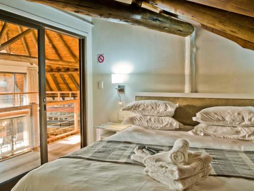 a bedroom with two beds with towels on them at Silverstreams Lodge, Villas & Cottages, Oribi Gorge in Glendale