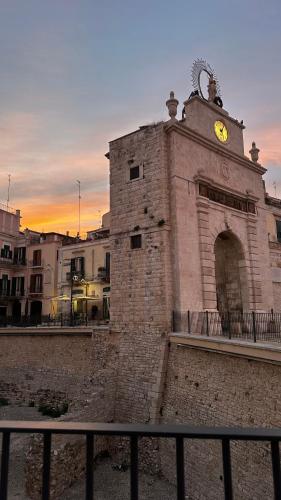 an old brick building with a clock on it at B&B Porta Baresana in Bitonto