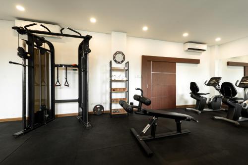 a gym with two treadmills and weights in a room at Niraxay Apartment in Vientiane
