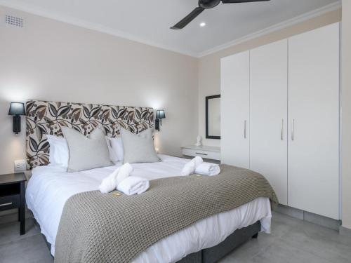 a bedroom with a large bed with towels on it at Silverstreams Lodge, Villas & Cottages, Oribi Gorge in Glendale