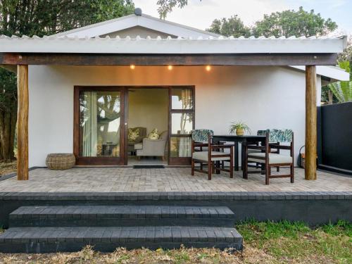 an outdoor patio with a table and chairs at Silverstreams Lodge, Villas & Cottages, Oribi Gorge in Glendale