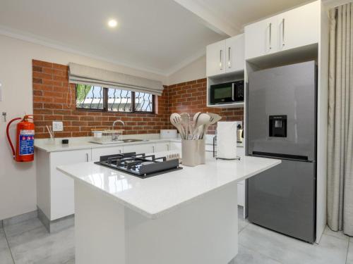 a kitchen with white countertops and a brick wall at Silverstreams Lodge, Villas & Cottages, Oribi Gorge in Glendale