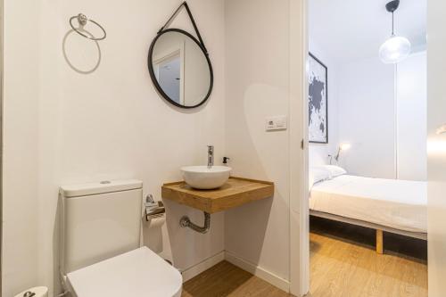 Un baño con lavabo, inodoro y una cama. en Allo Apartments Santa María III Centro Loft, en Jerez de la Frontera