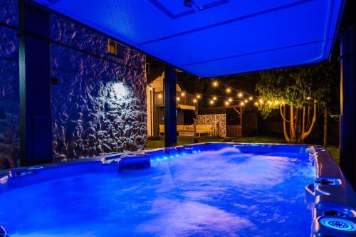 a hot tub in a backyard at night with lights at Farm House at Mochdre Cottages in Conwy