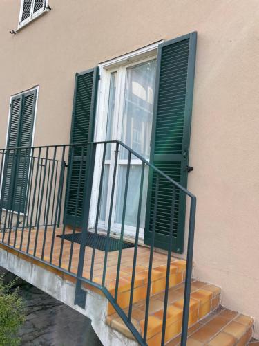 a balcony with green shutters on a building at Volta 8 in Cassano Magnago