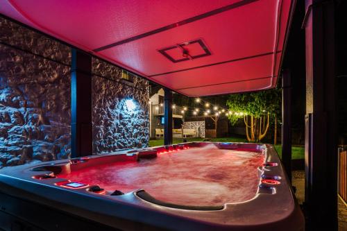 a pool table in a room with a pink lighting at Farm House at Mochdre Cottages in Conwy