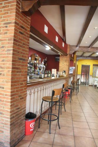 a bar in a restaurant with tables and chairs at Hostal Zaguan in Talaveruela