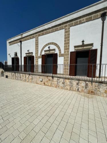 a brick building with three windows and a patio at Borgo Angelica B&B in Leporano Marina
