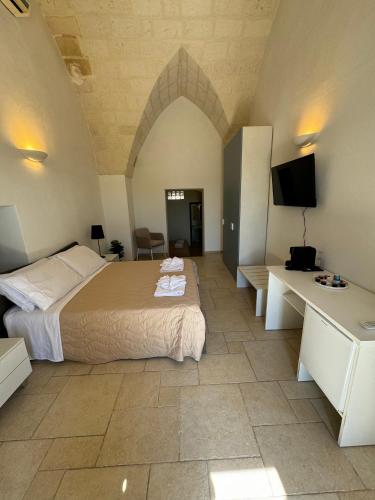 a bedroom with a bed and a tv in a room at Borgo Angelica B&B in Leporano Marina