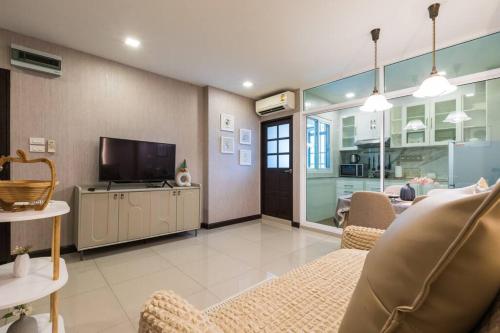 a living room with a couch and a television at BKK Sukumvit71 1 Bed 2 Bath 1 Living 1 Kitchen in Bangkok