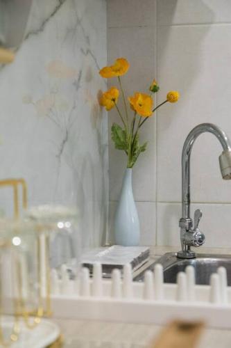 a kitchen sink with a vase with yellow flowers in it at BKK Sukumvit71 1 Bed 2 Bath 1 Living 1 Kitchen in Bangkok