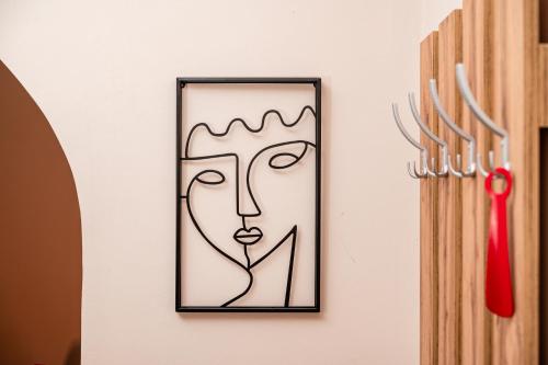 a picture of a face on a wall next to a knife at Cozy apartment in city center in Belgrade