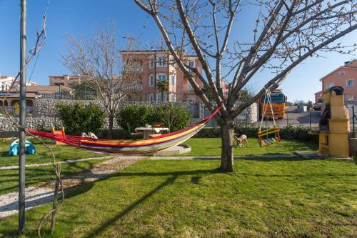 a hammock hanging from a tree in a yard at Apartments Villa Bare in Kastav
