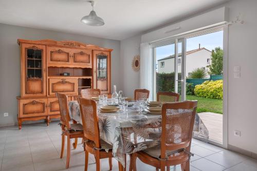 une salle à manger avec une table et des chaises dans l'établissement Maison de plain-pied - quartier calme pour six personnes, à La Plaine-sur-Mer