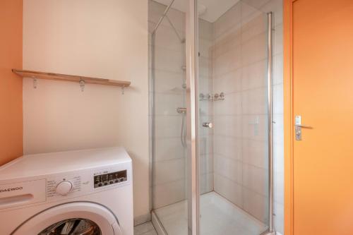 eine Waschmaschine in einem Badezimmer mit Dusche in der Unterkunft Maison de plain-pied - quartier calme pour six personnes in La Plaine-sur-Mer