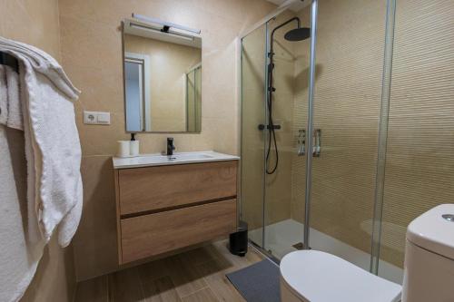 Un baño con ducha, lavabo e inodoro. en Apartamentos Turisticos José Cruz, en Nerja
