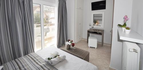 une chambre blanche avec un lit et un balcon dans l'établissement Green View Apartments, à Thasos