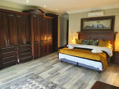 a bedroom with a large bed with a wooden headboard at Zimbali Coastal Resort Yellowwood House in Ballito