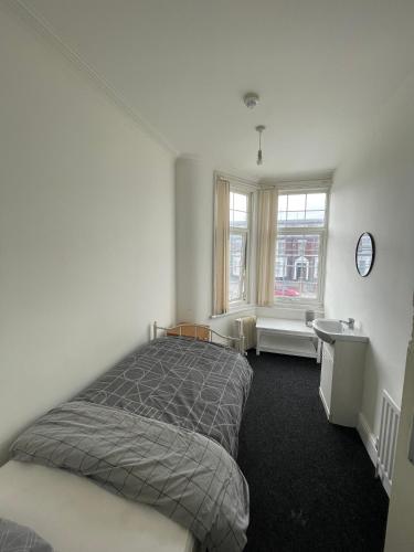 a bedroom with a bed and a desk and a window at Southfiled road in Middlesbrough