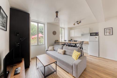 un salon avec un canapé et une cuisine dans l'établissement Cocon Cozy - 10 min Disney - Cozy Houses, à Bussy-Saint-Georges