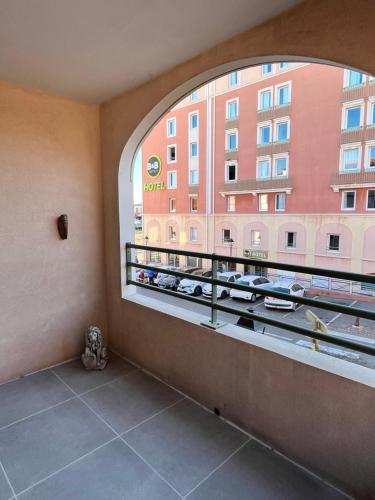 a room with a window with a view of a building at Appartement Les Terrasses du Port in Port-de-Bouc