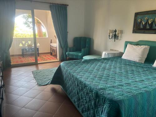 Villa Domina Coral Bay في شرم الشيخ: غرفة نوم مع سرير مع لحاف أخضر