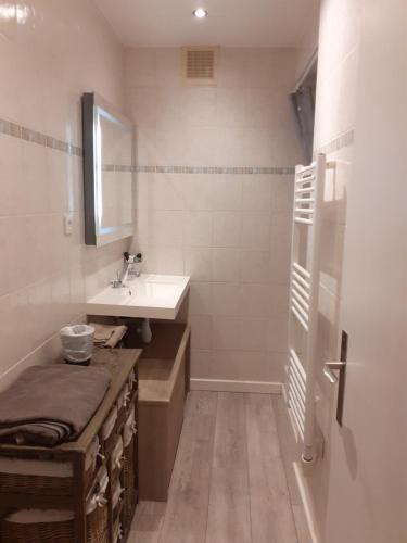 une salle de bain blanche avec un lavabo et un miroir dans l'établissement Ambiance provençale, à La Seyne-sur-Mer