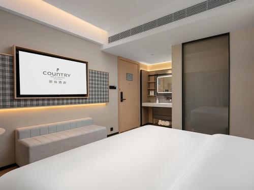 Postel nebo postele na pokoji v ubytování Country Inn & Suite by Radisson, Guangzhou Railway Station Xiaobei