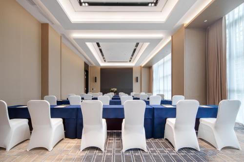 a conference room with a blue table and white chairs at Grand Mercure Wuhan Hanyang in Wuhan
