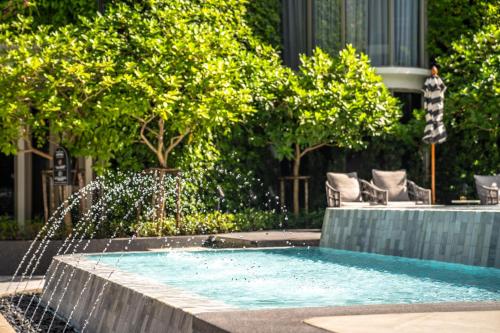 a swimming pool with a water fountain at The Salil Hotel Riverside Bangkok in Bangkok