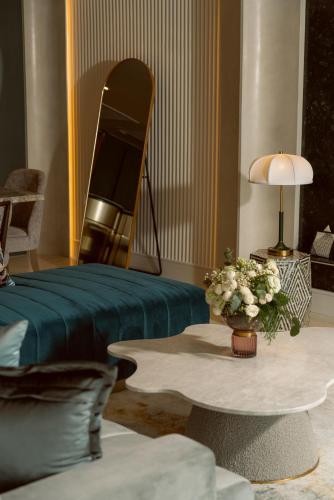 a living room with a bed and a table with flowers at The Salil Hotel Riverside Bangkok in Bangkok