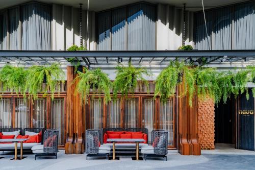 a group of chairs and tables in front of a building at The Salil Hotel Riverside Bangkok in Bangkok